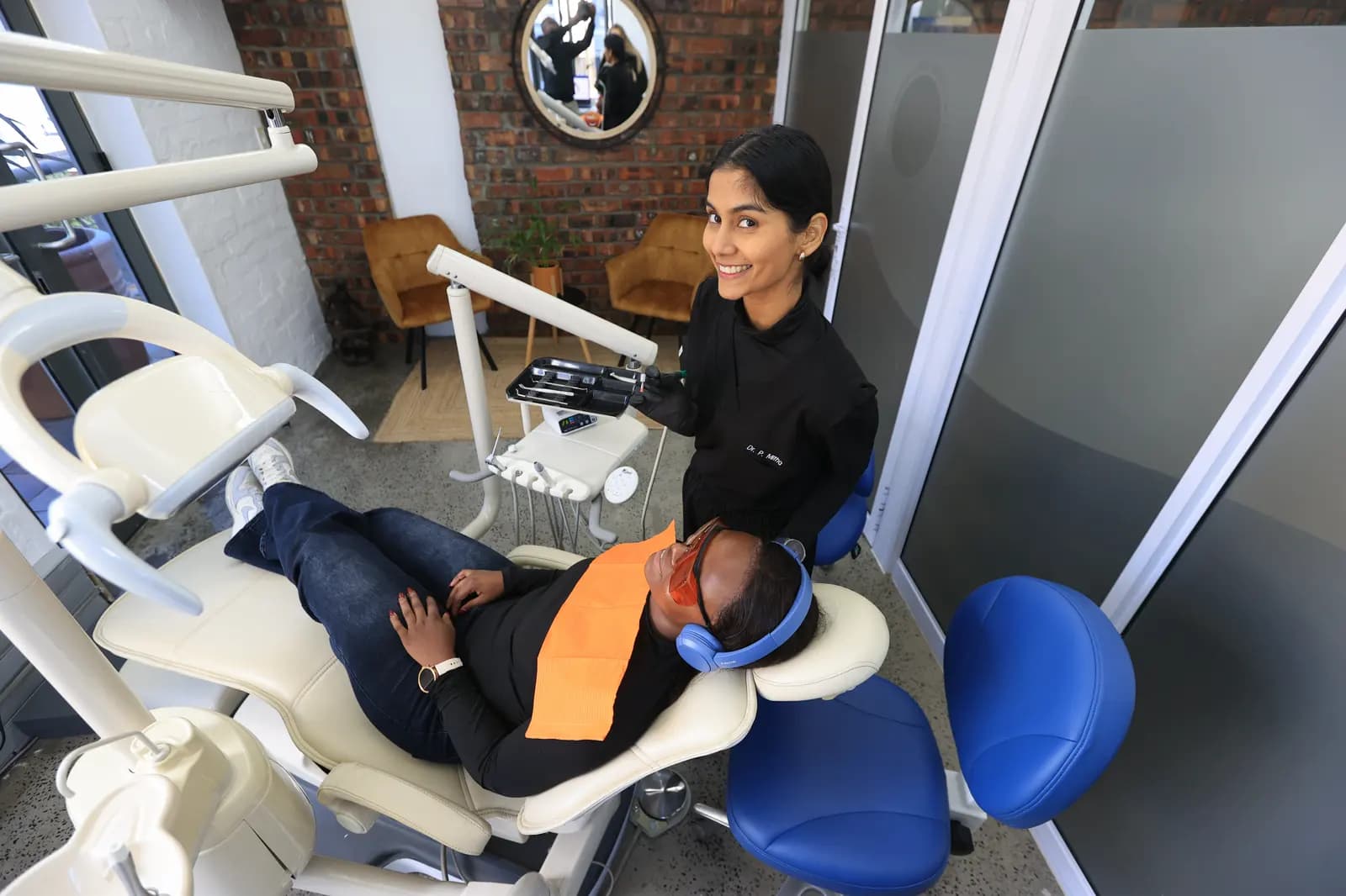 Overhead of a dentist and patient against a brick wall
