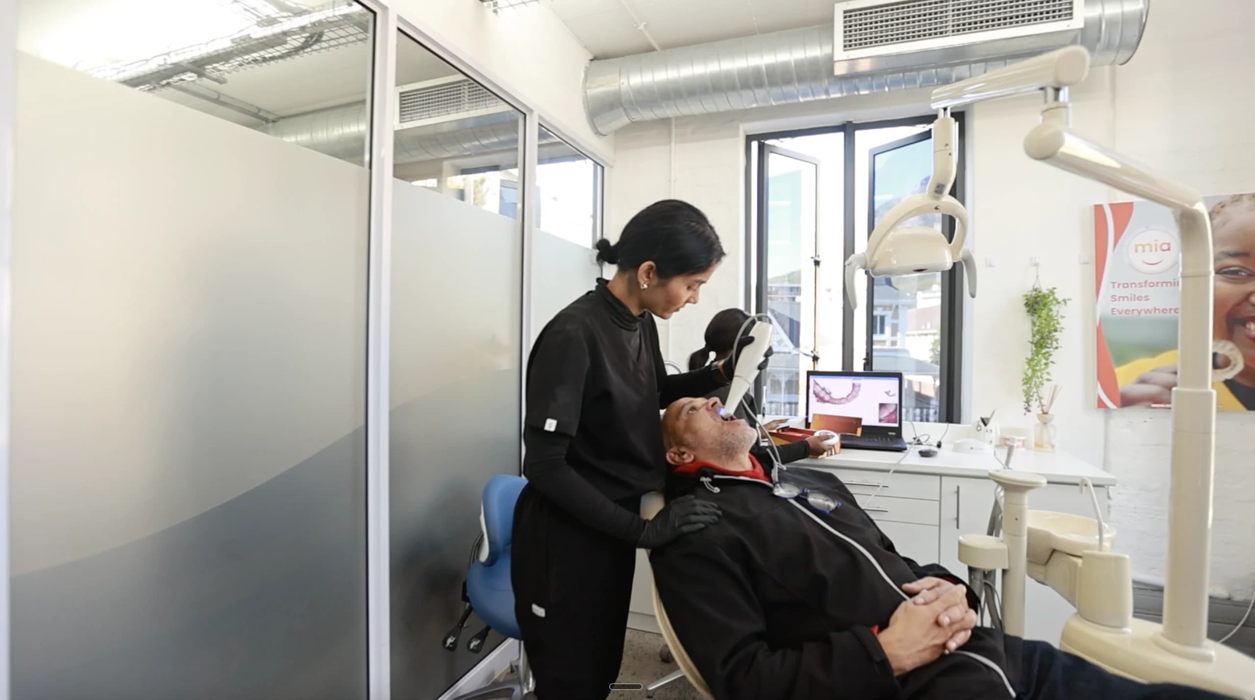 Female dentist treating a patient at Mia