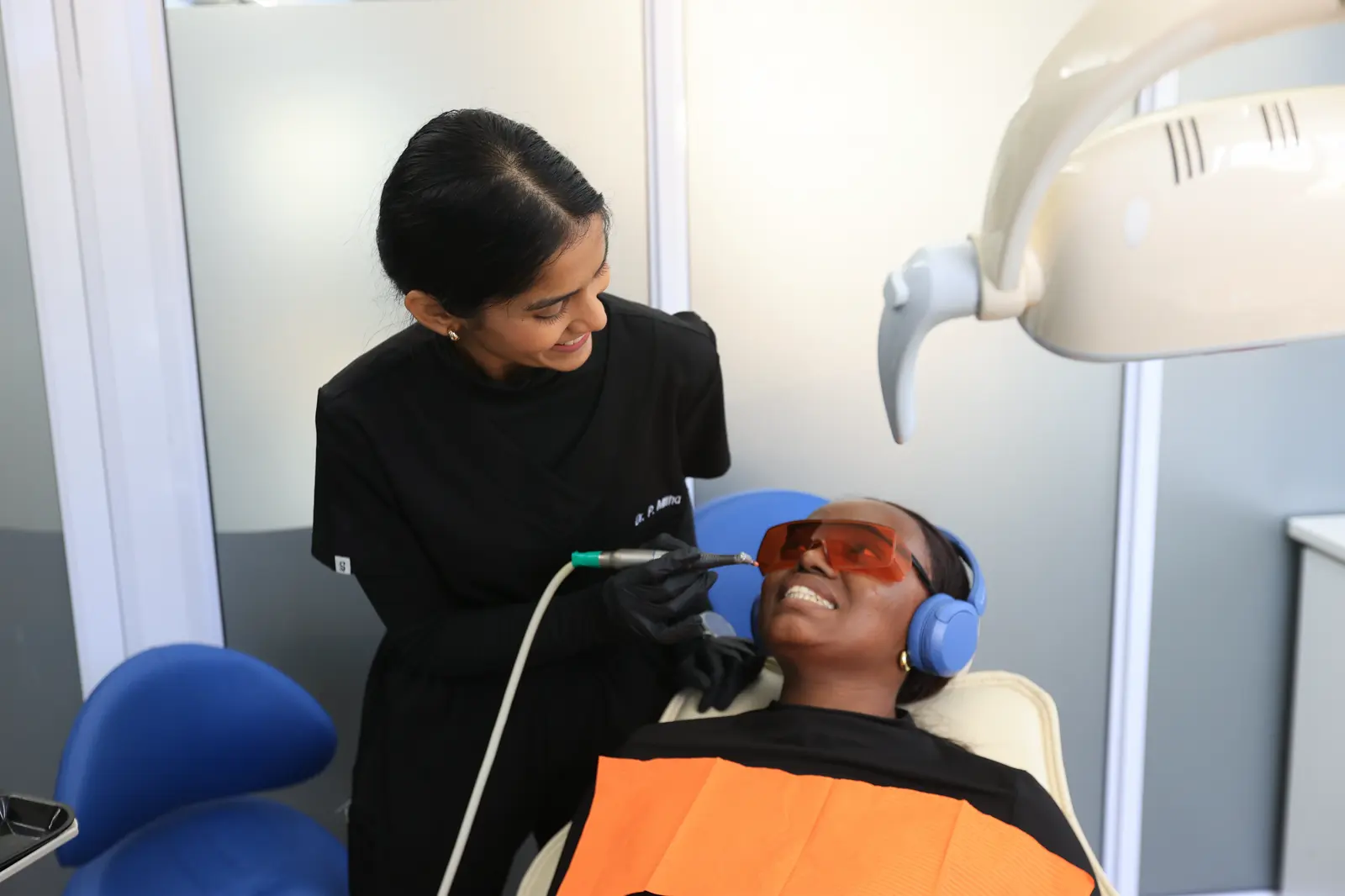 Dentist cleaning a smiling patient's teeth
