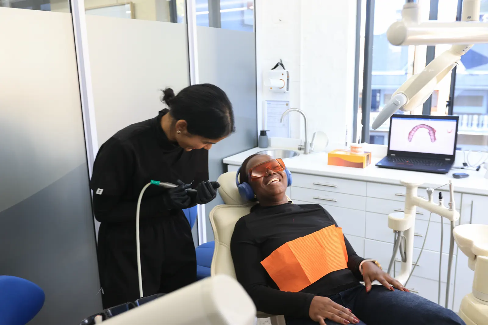 A dentist and a laughing patient looking at a scan
