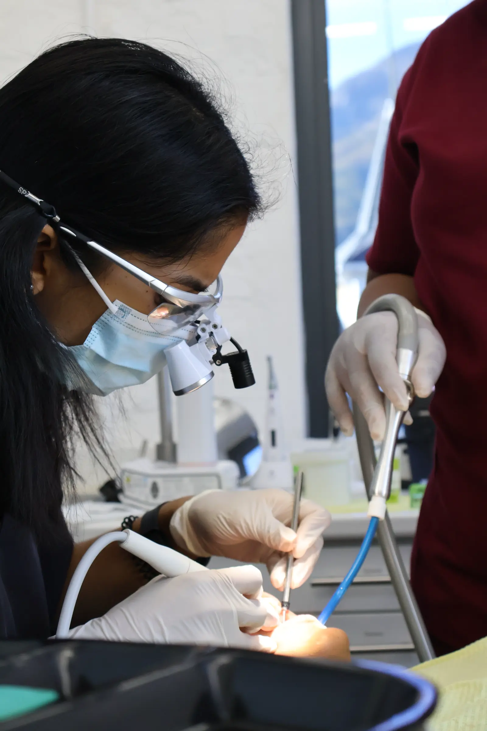 Dentist wearing loupes treating a patient