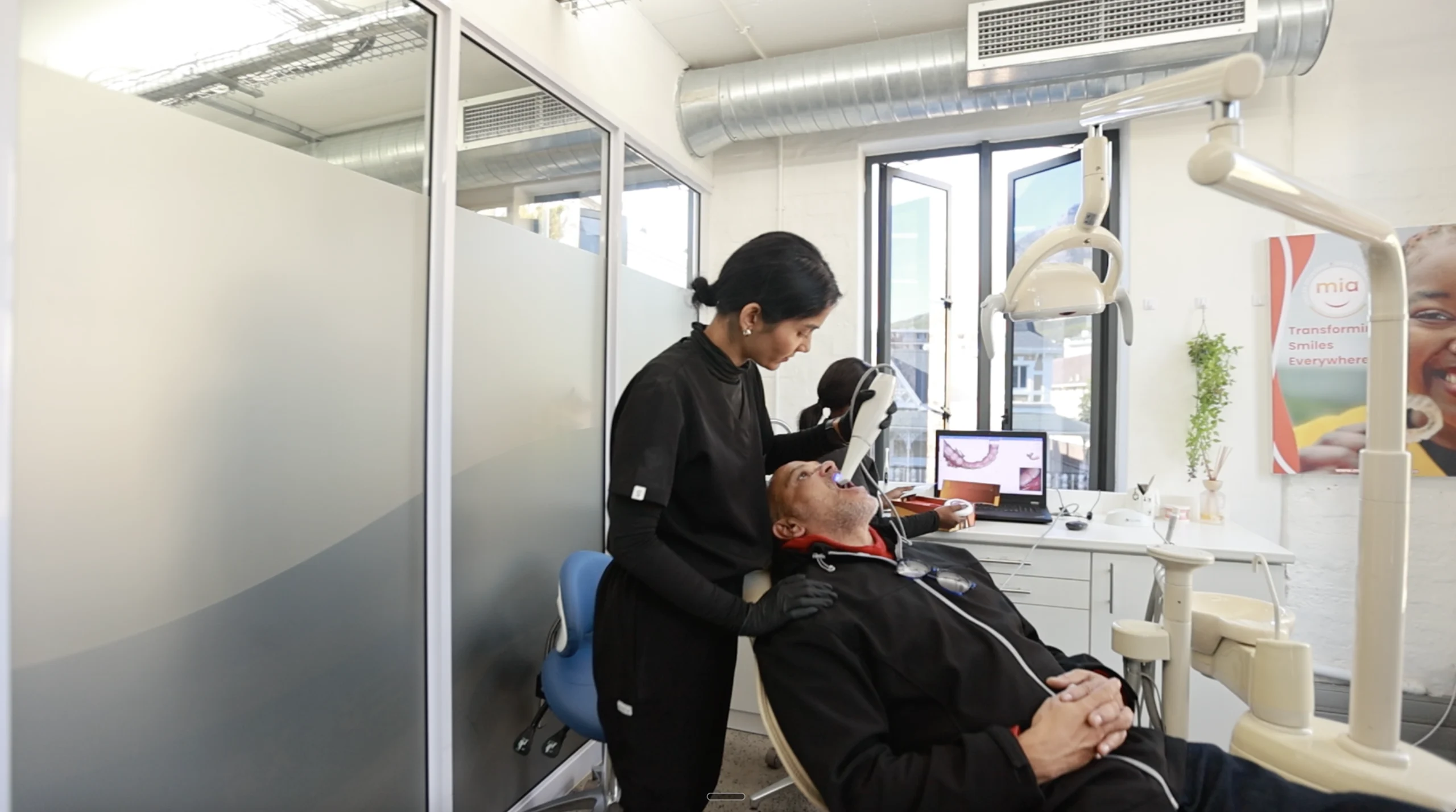 Female dentist treating a patient at Mia