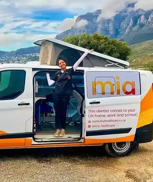 Dr Soni beside the Mia mobile clinic with its pop-up roof raised